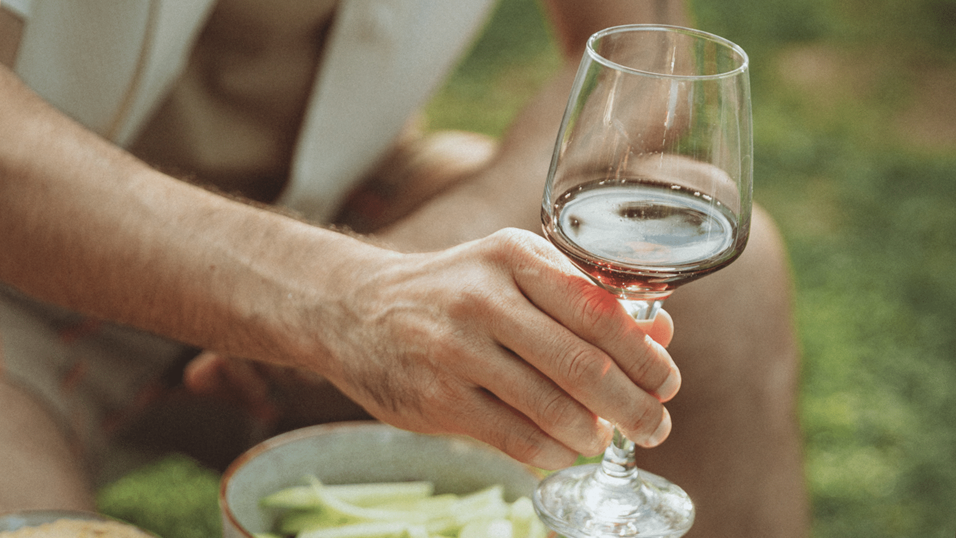 Une main d'homme tient un verre de vin