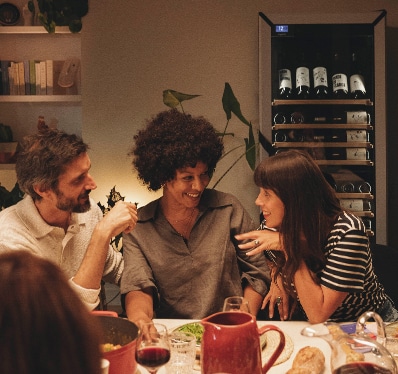 Trois personnes discutent autour d'un repas