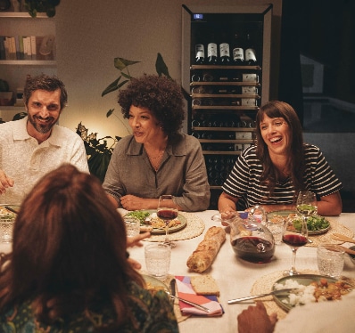 5 personnes autour d'une table partagent un repas en intérieur