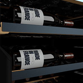 Deux bouteilles de vins couchées sur des étagères dans une cave à vin.