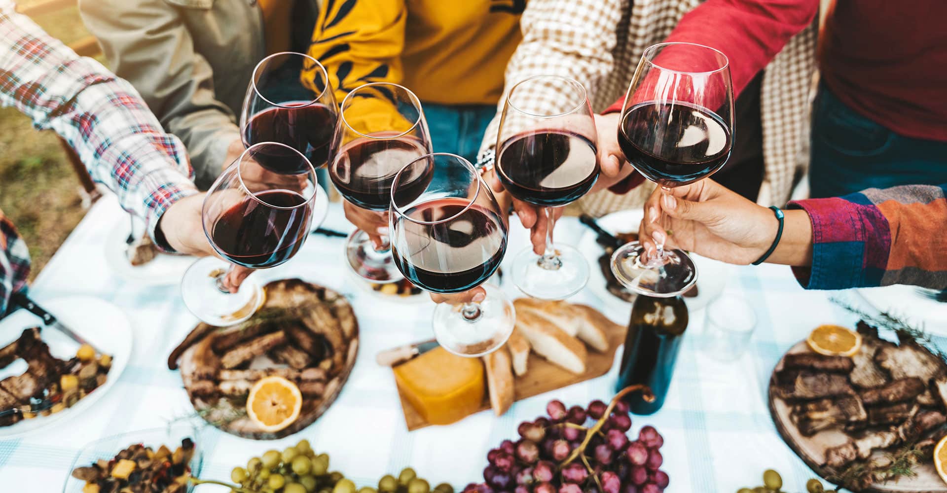 Plusieurs personne trinquent au-dessus d'une table.