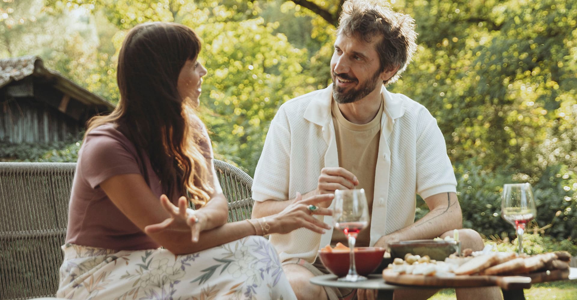 Un homme et une femme prennent un apéritif dans un jardin.